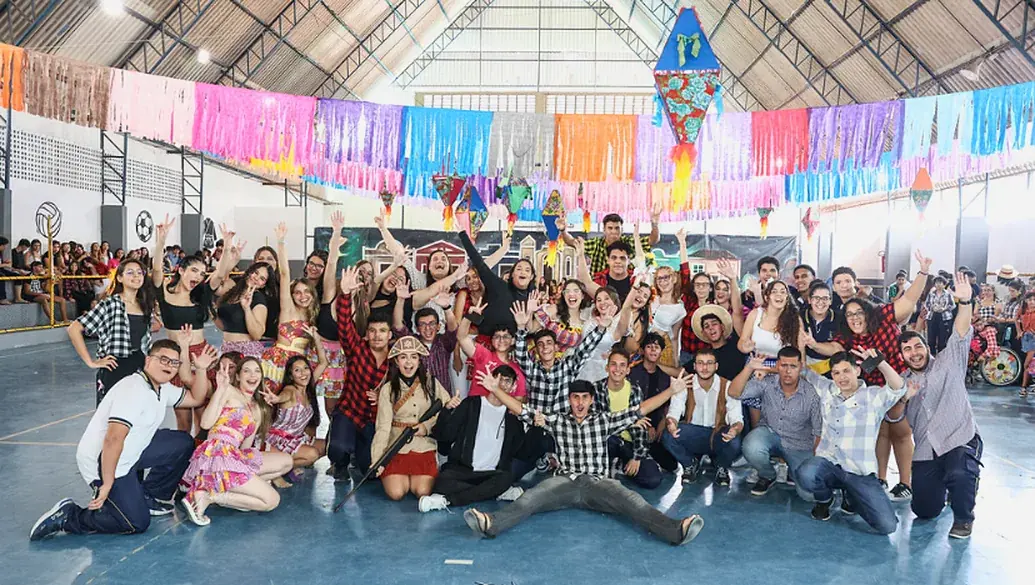 Alunos com roupas de São João no ginásio decorado