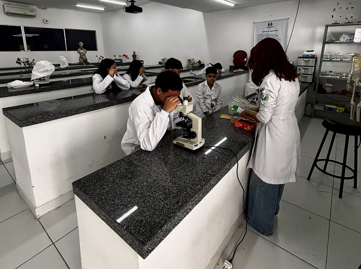 Alunos de jaleco em aula prática no laboratório